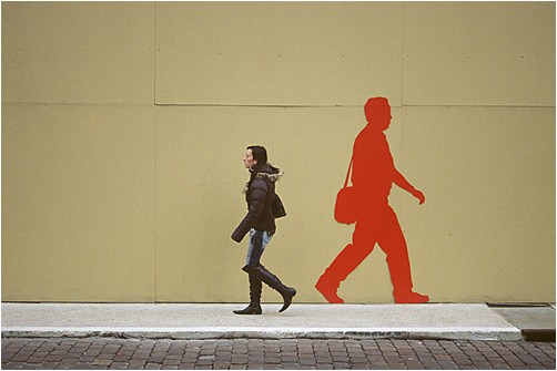 Passantin vor einem Bauzaun | woman passing by a hoarding 